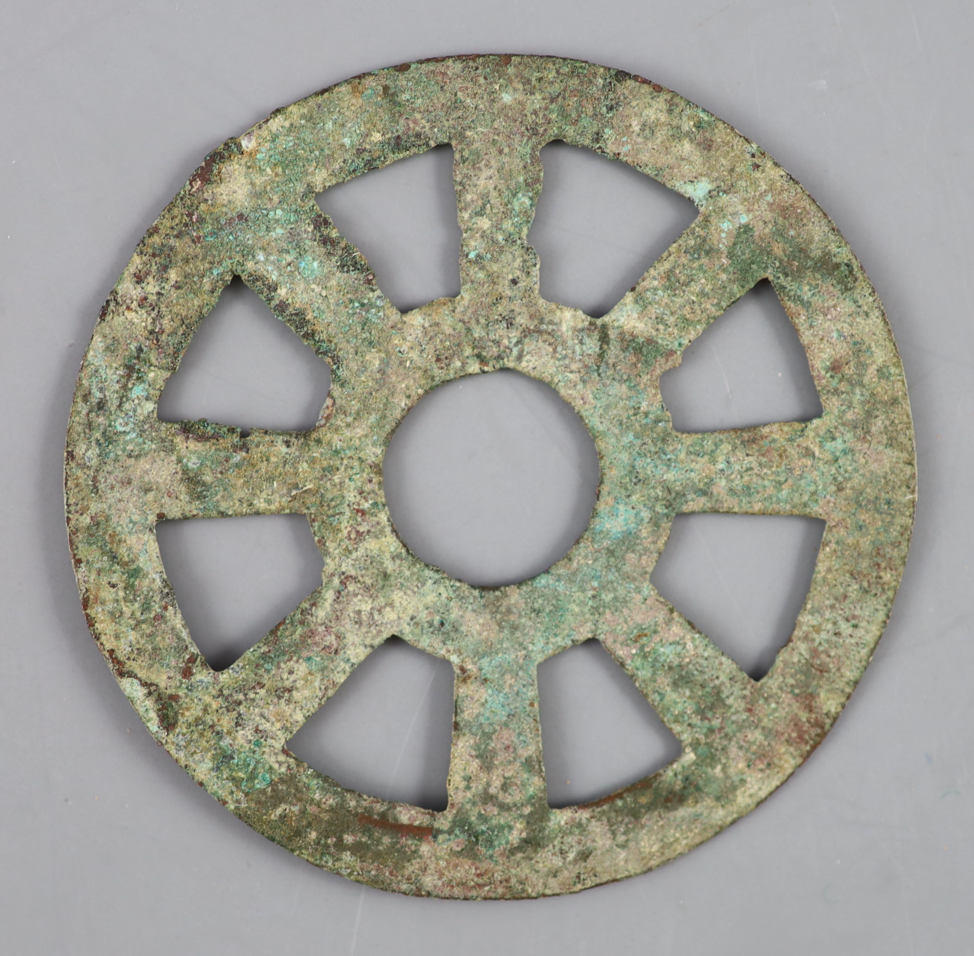 China, a rare archaic bronze openwork Dharmachakra (wheel) charm, probably Han-Tang dynasty,